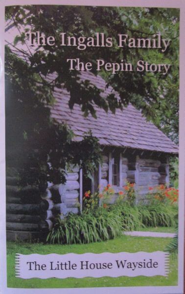 A log cabin surrounded by trees and flowers, with text about the Pepin Story and The Ingalls Family at The Little House Wayside.