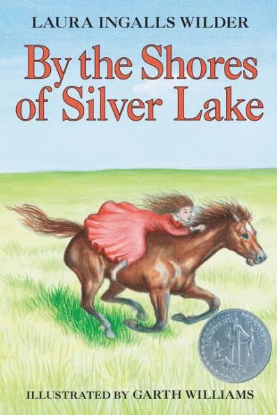 A girl in a red dress rides a galloping brown horse across a grassy field, with the book title "By the Shores of Silver Lake" displayed above.