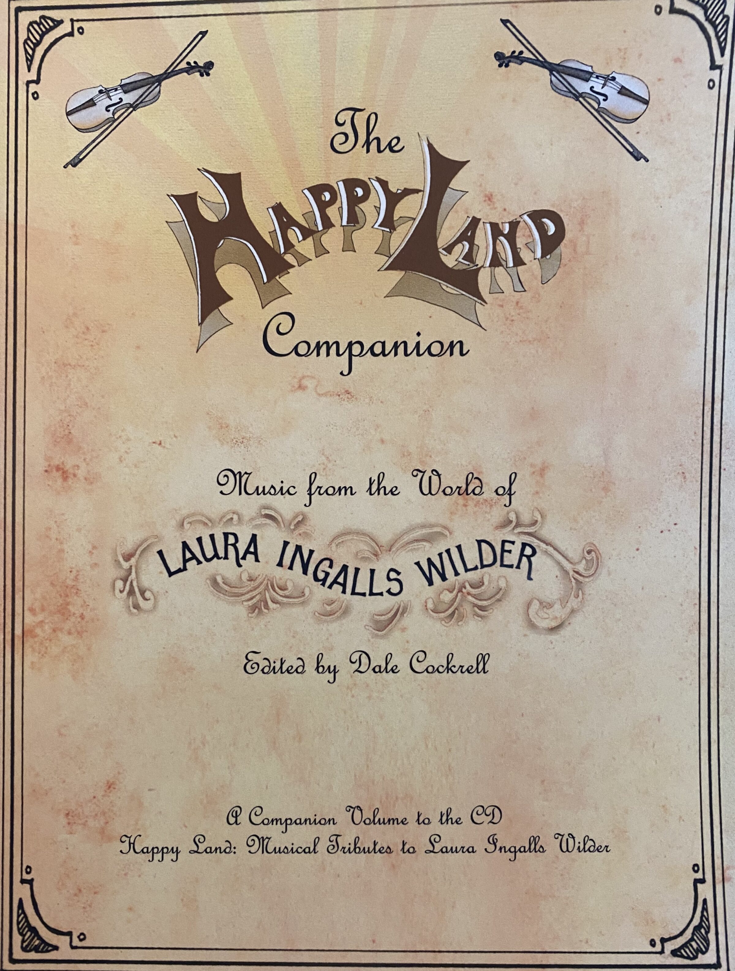 Book cover titled "Happy Land Companion," featuring violins and elegant, ornate text.