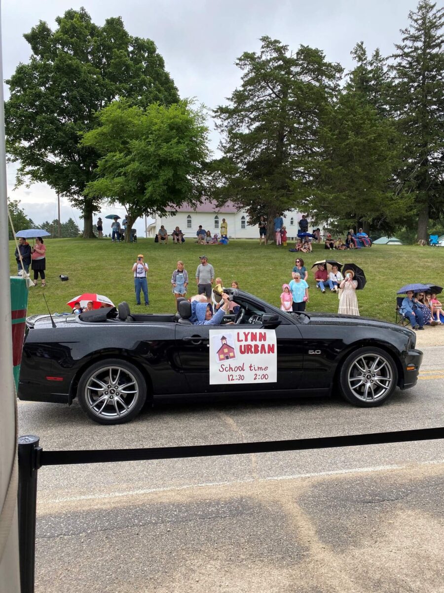 Black convertible in a parade with a 